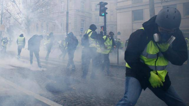 Polisi menembakkan gas air mata kepada massa aksi Rompi Kuning di Paris, Prancis, Sabtu (8/12/2018).